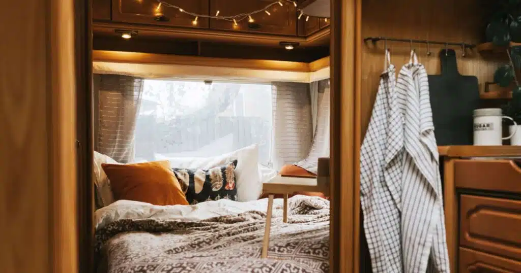 RV bedroom with fairy lights, hooks, and other decor